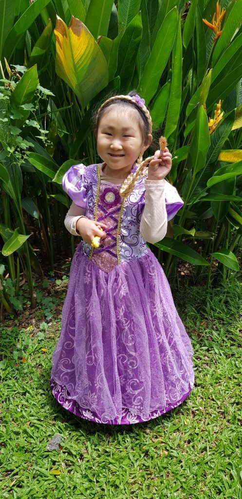 Image shows beneficiary Ho Wen Xi posing in her favourite princess dress